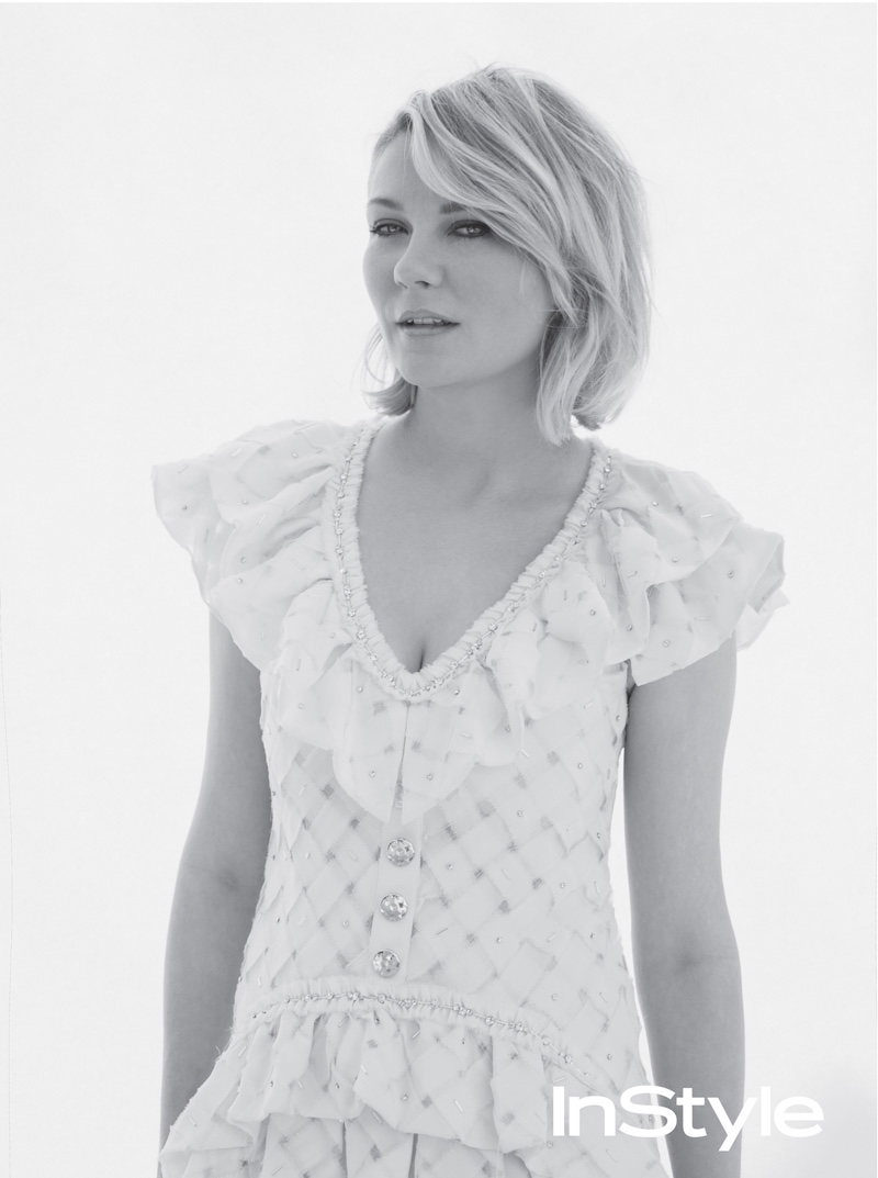 Photographed in black and white, Kirsten poses in a Chanel dress with ruffles