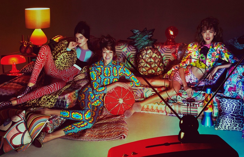 The models lounge around the television wearing colorful prints