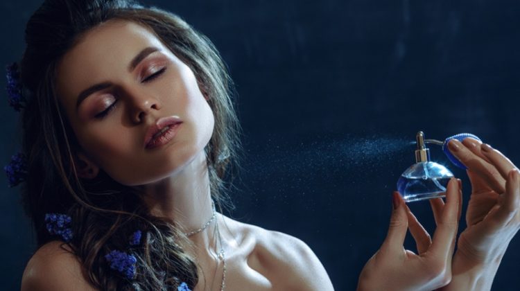 Beauty Model Spraying Perfume Blue Bottle