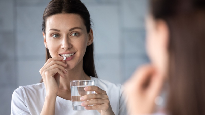 Woman Taking Vitamin Glass Water