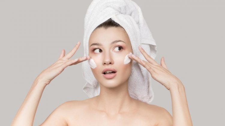 Model Applying Moisturizer Face Skincare Towel