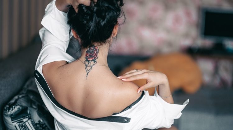 Woman Showing Red Rose Tattoo Back Neck