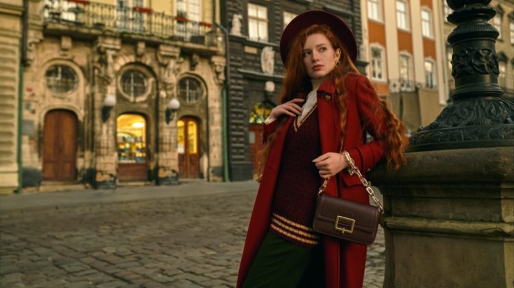 model red coat sweater vest hat brown bag