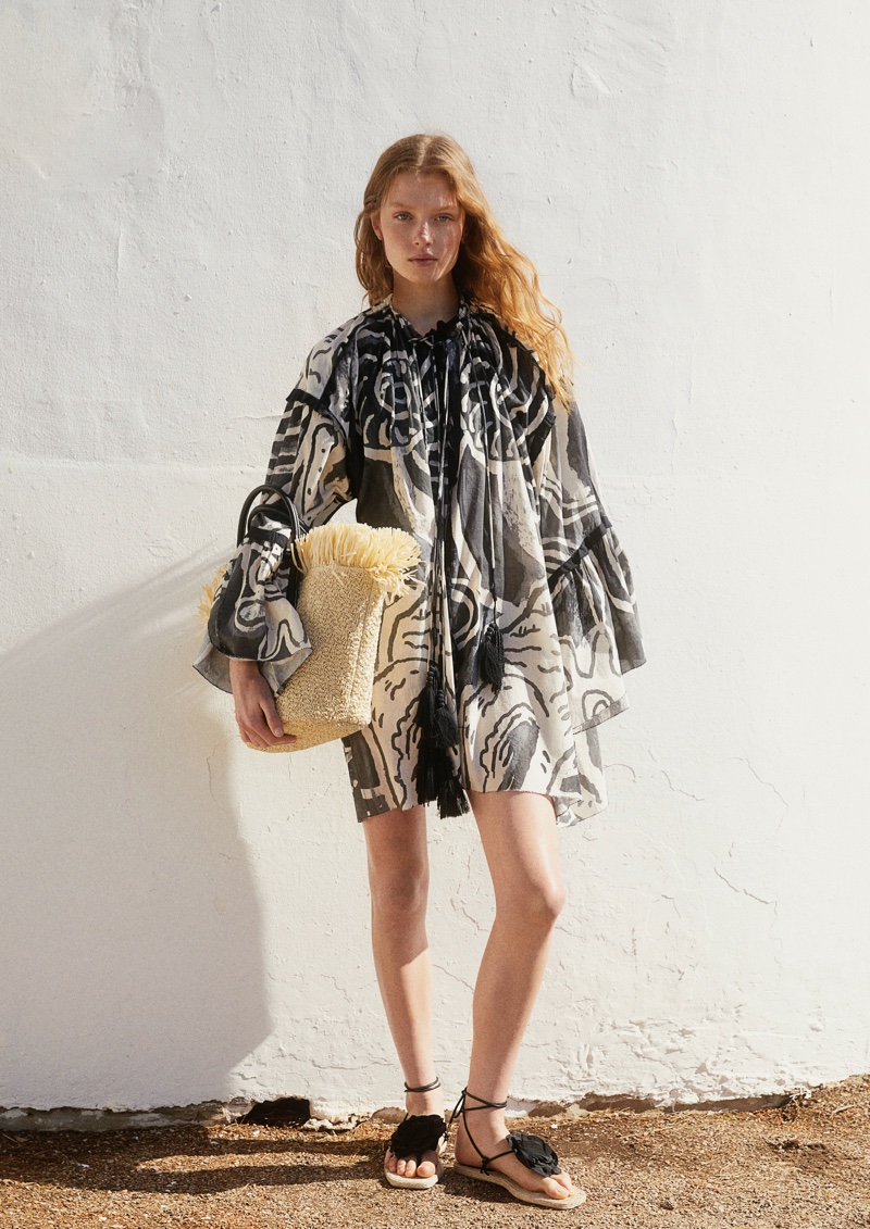 H&M Studio's summer 2024 capsule collection highlights a chic, printed kaftan with a straw tote.