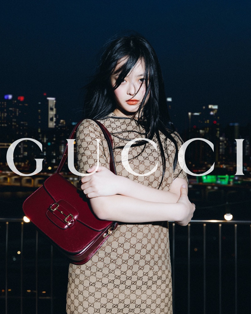 Modeling a printed dress, Hanni poses with the Gucci Horsebit 1955 bag in Seoul.