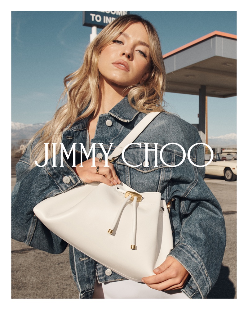 Wearing denim, Sydney Sweeney poses with the Bon Bon East West bag in Jimmy Choo's summer 2024 ad.