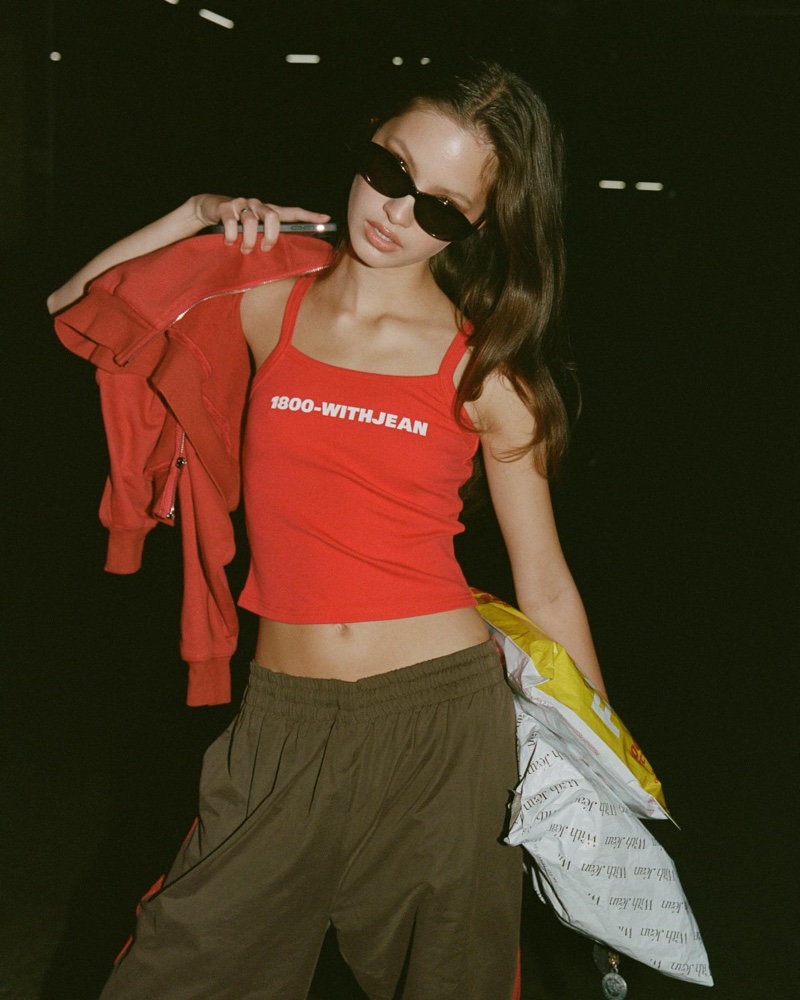 With Jéan's eye-catching red tank top, paired with a casual zip-up and sporty trousers bring a retro-inspired look.