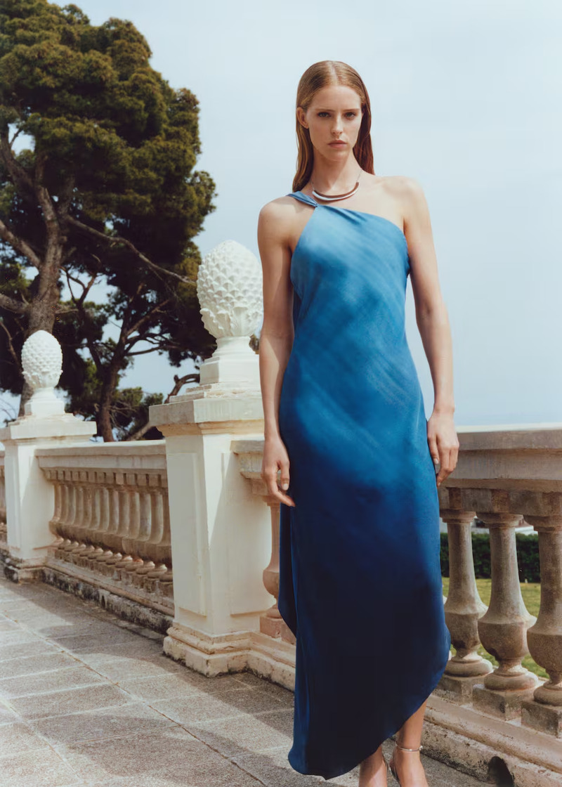 Abby Champion models a one-shoulder blue gradient dress from Mango's summer 2024 party dress edit.