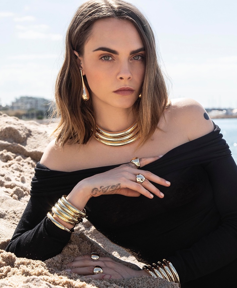 Wearing stacked gold bracelets, necklaces, and rings, Cara Delevingne shines in APM Monaco designs.