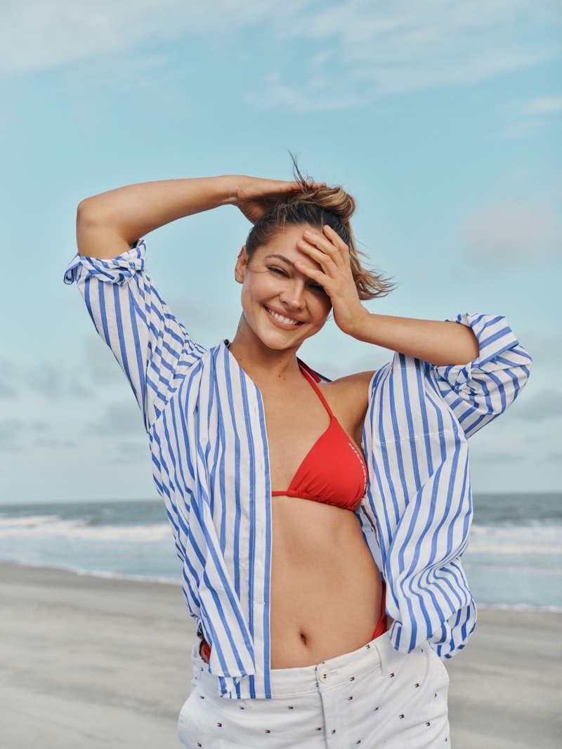 All smiles, Madelyn Cline wears red bikini top with a striped shirt for Tommy Hilfiger's summer 2024 campaign.