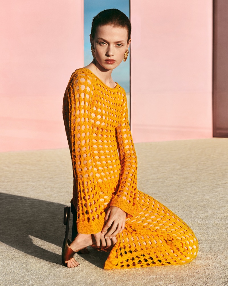 Ella Mccutcheon wears an orange openwork knit dress from Mango's summer arrivals.