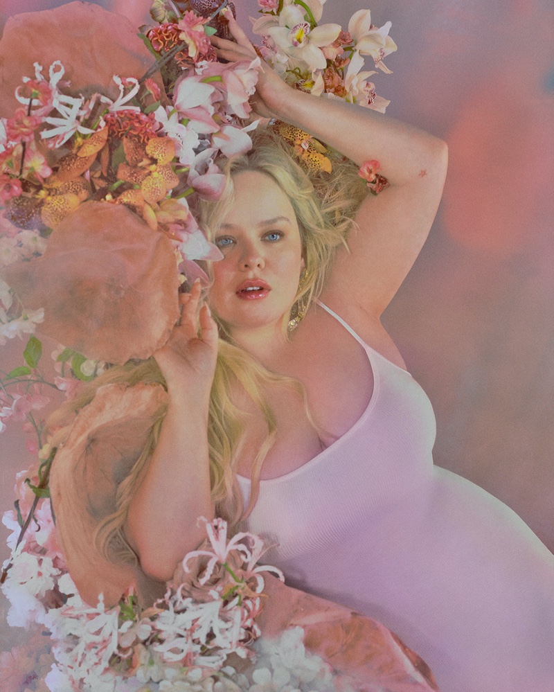 Surrounded by flowers, Nicola Coughlan fronts SKIMS Soft Lounge collection.