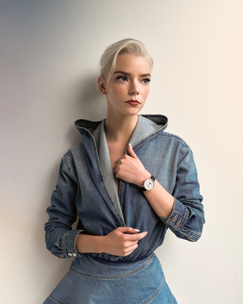 Wearing a denim ensemble, Anya Taylor-Joy shows off the Rendez-Vous Moon watch from Jaeger-LeCoultre.