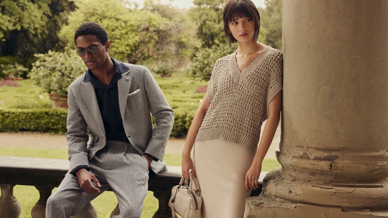 Nabila Leunig shows off a knit vest with a sleek vest alongside Hamid Onifade for Brunello Cucinelli.