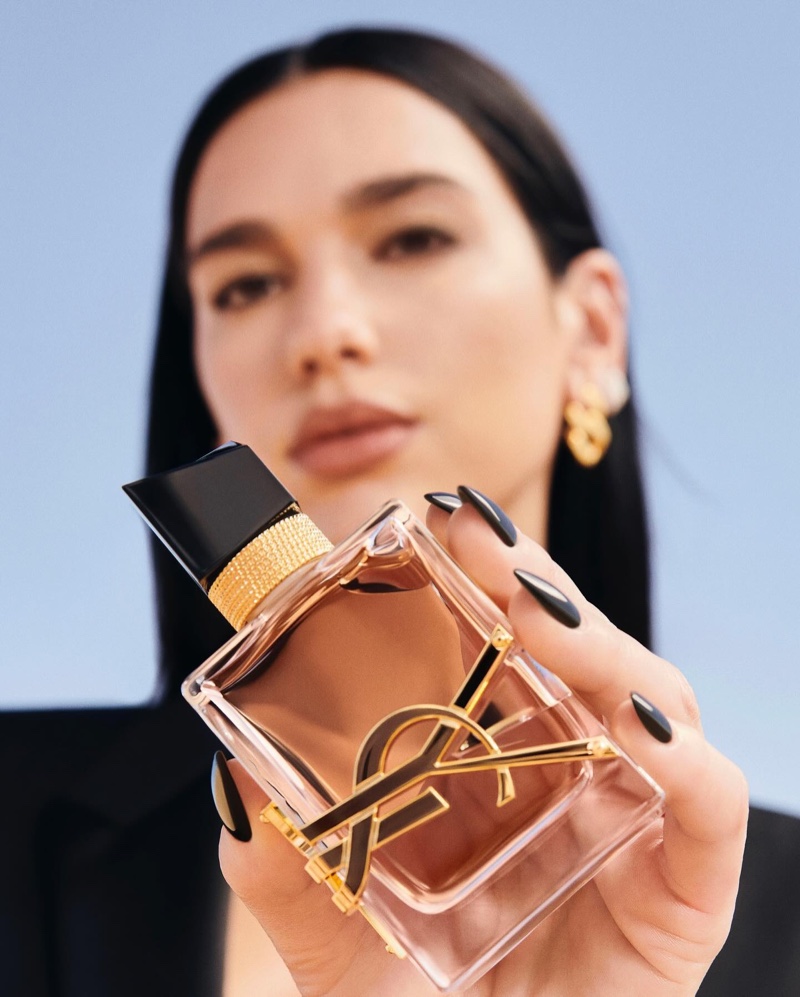 Dua Lipa shows off the glittering perfume bottle of YSL's new Libre reiteration called: Flowers & Flames.