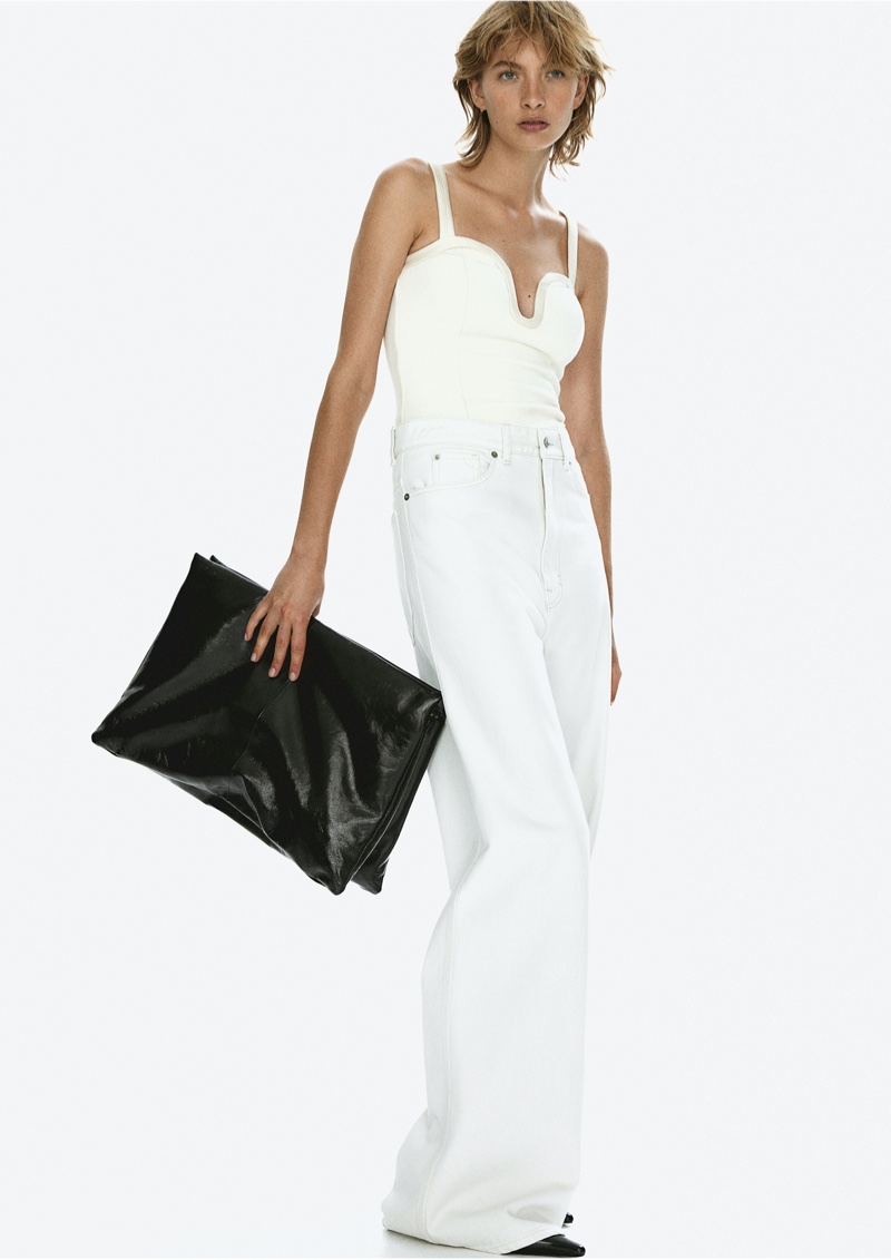 H&M Studio's pre-fall 2024 line features a white bustier paired with wide-leg jeans and an oversized clutch.