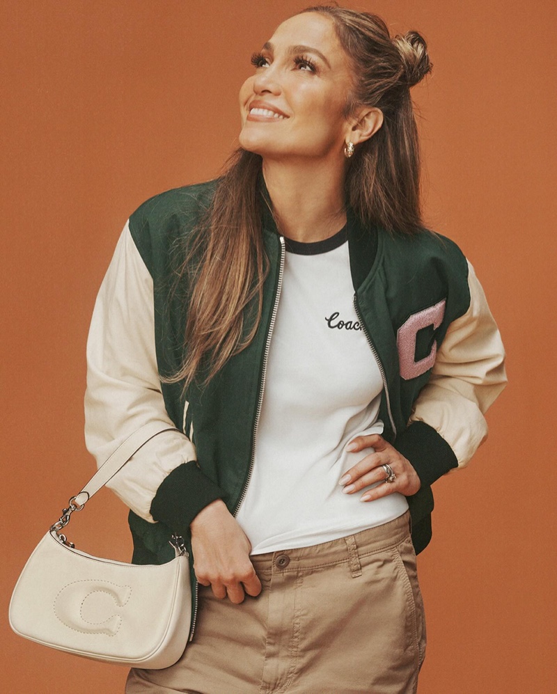 Jennifer Lopez is all smiles wearing a bomber jacket in 2024 Coach ad.