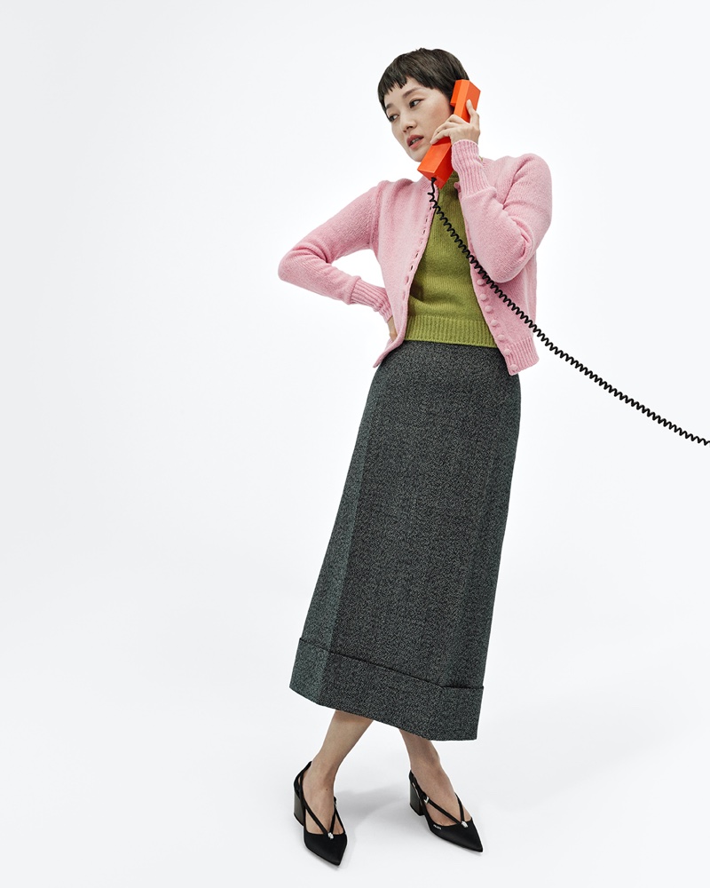 Yili Ma wears a cardigan, knit top, and midi-length skirt for Prada's fall-winter 2024 campaign.