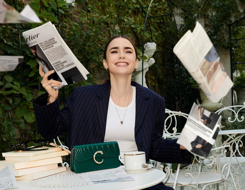 Posing in Paris, Lily Collins models with a green Cartier bag.