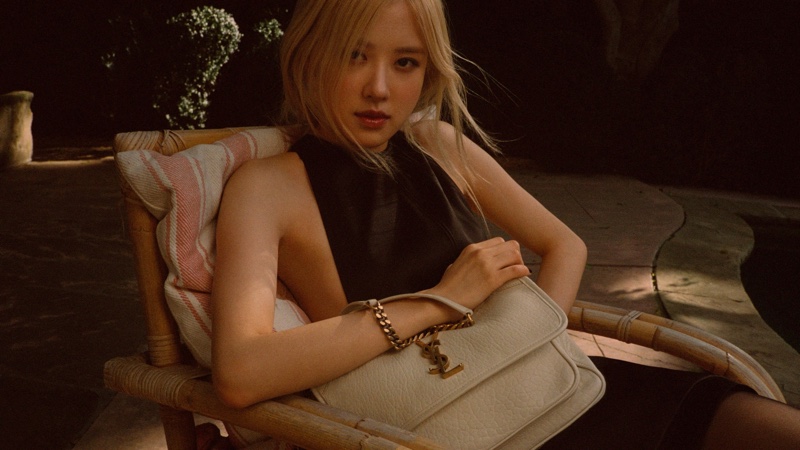 Rose poses for Saint Laurent's Tan Lines capsule, wearing the Niki bag.