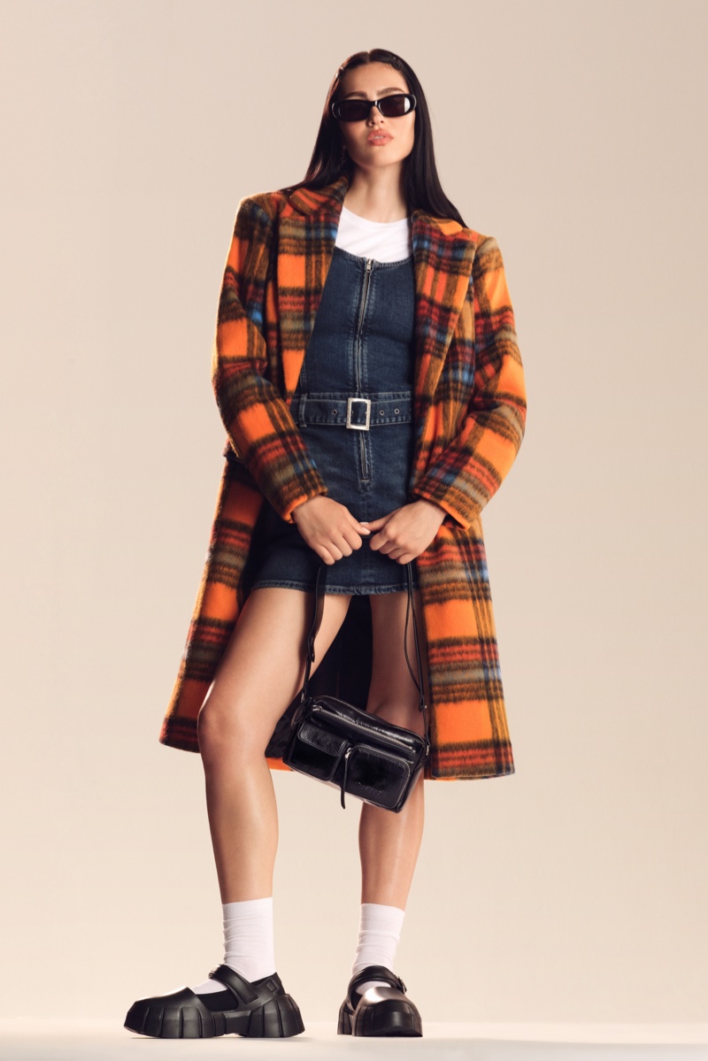 Amelia Gray gets preppy chic in a plaid jacket and denim dress for Desigual's fall 2024 campaign.