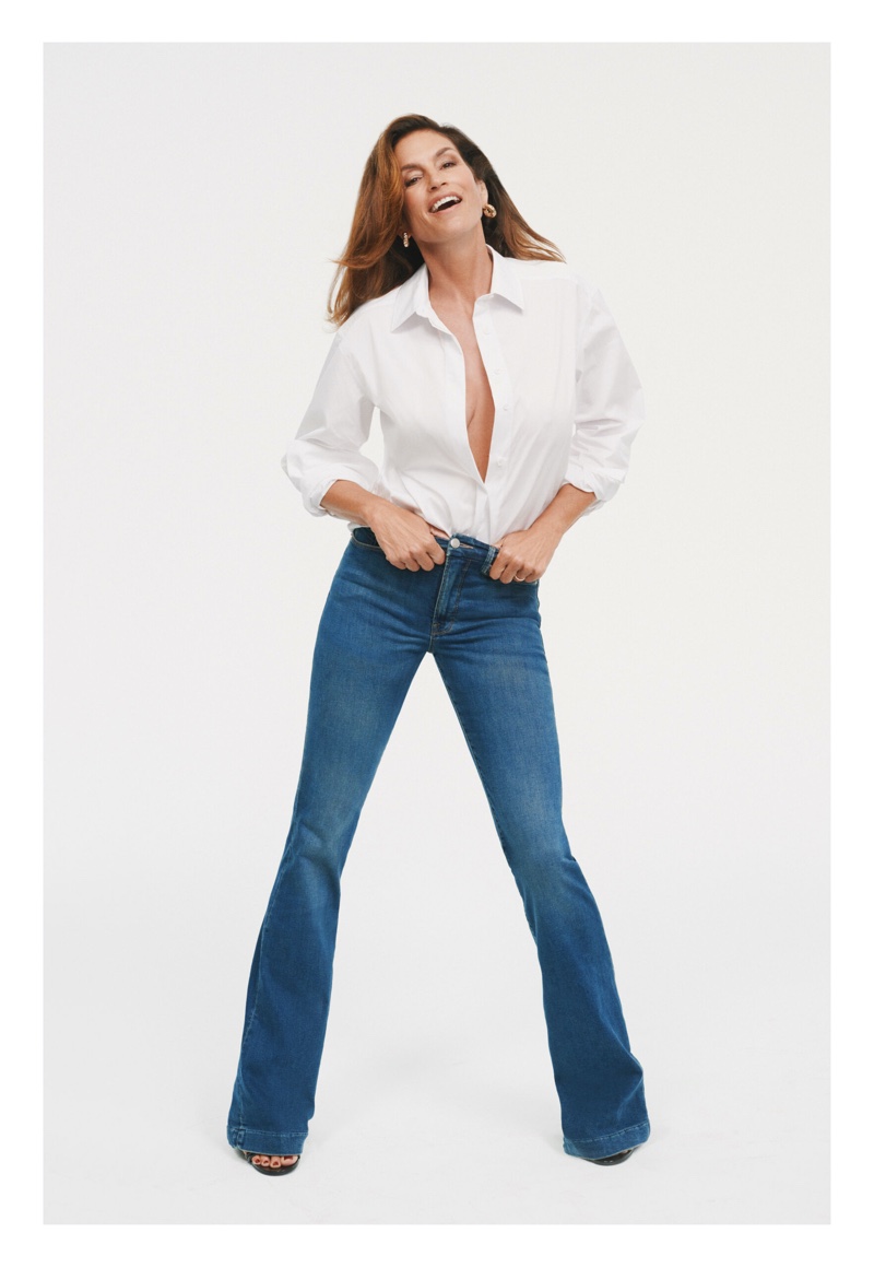 All smiles, Cindy Crawford wears Good American's button-up shirt and flared jeans.