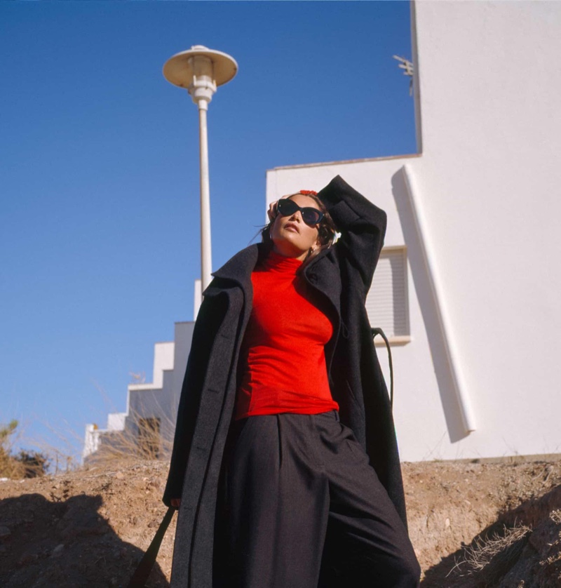 Laetitia Casta layers up in a Massimo Dutti coat, sweater, and trousers.