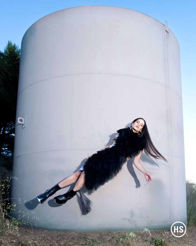 Rosalía defies gravity in a black dress.