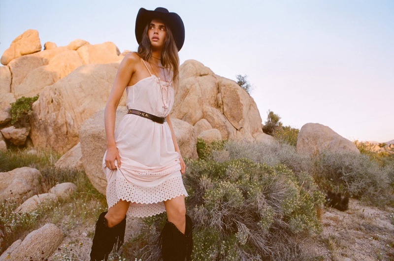 Zoi Mantzakanis channels western vibes in a white dress and cowboy hat for Spell's Rebel Spirit campaign.