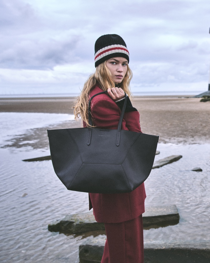 Devi Rae wears a red suit and tote bag from Brunello Cucinelli's winter 2024 collection.