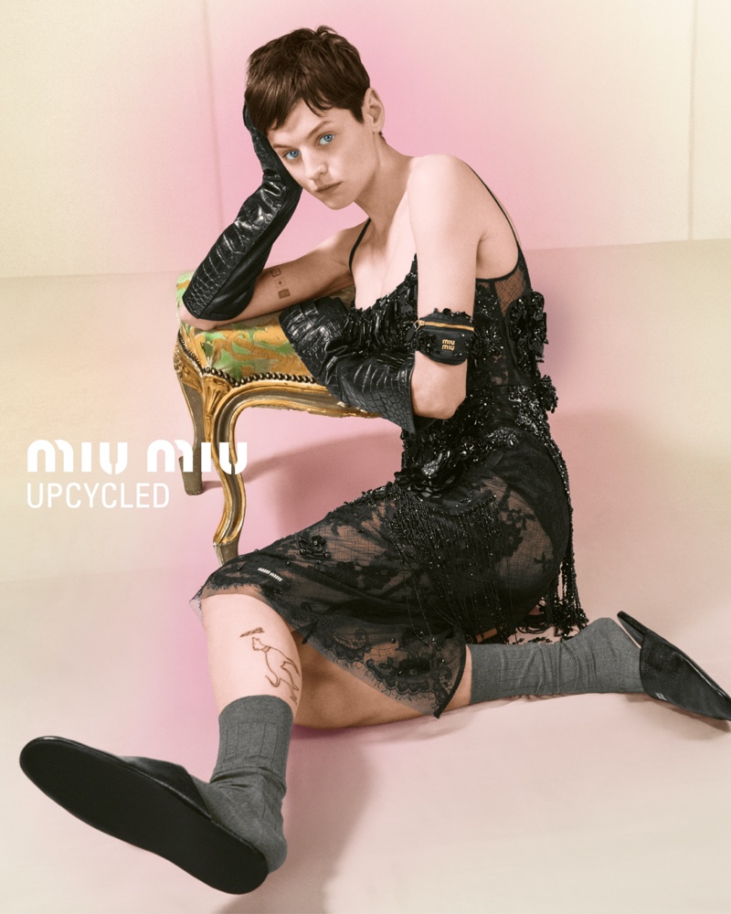 Emma Corrin wears a black slip dress for Miu Miu's Upcycled Holiday 2024 ad.