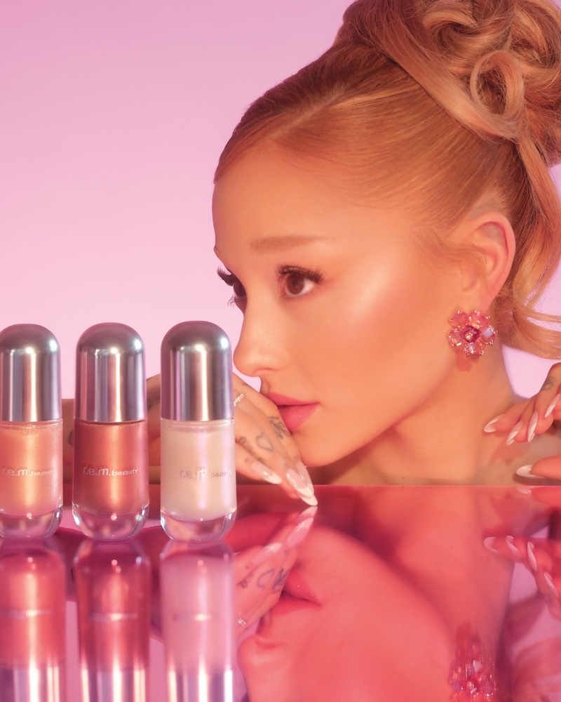 Ariana Grande poses with r.e.m. Beauty's Dreamglow Highlight Serum.