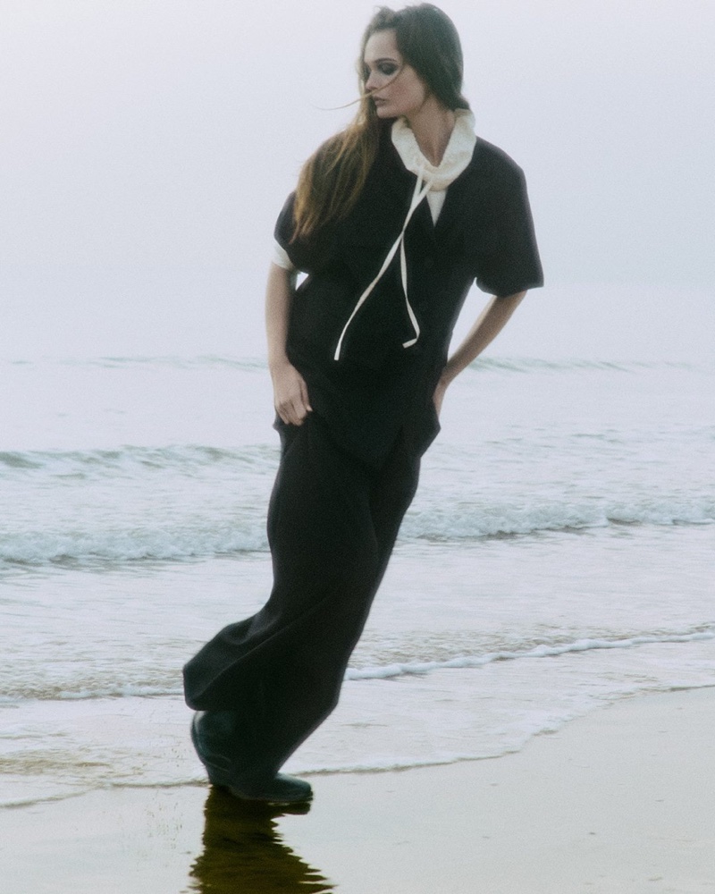 Lulu Tenney poses on the beach wearing COS' January 2025 arrivals.